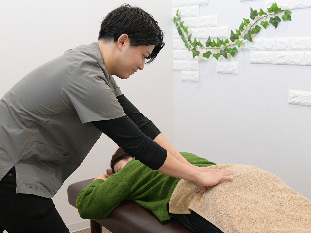 津市の整体『まはろ整体 河芸店』で腰痛改善のために骨盤と腰背部をケアする様子